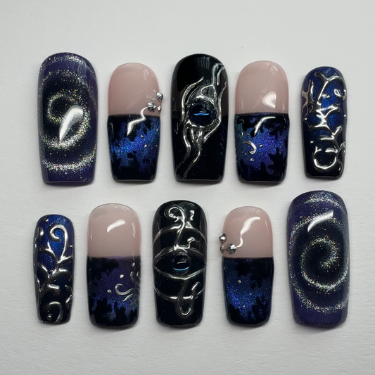 Nail art with black, blue, and beige designs on a white background